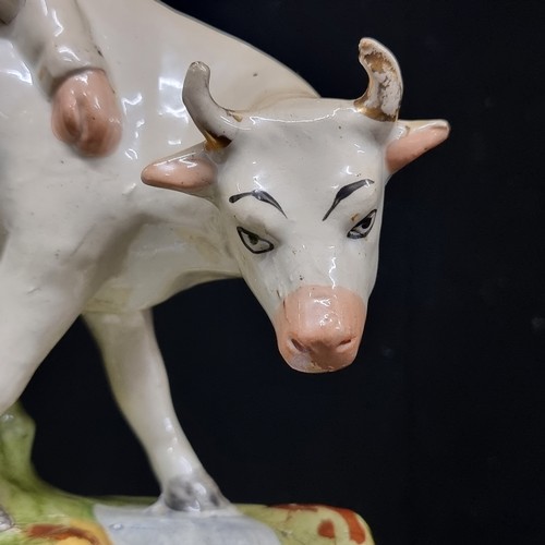 244 - A mid 19th century Staffordshire flatback figure  of A charming porcelain white cow accompanied by a... 