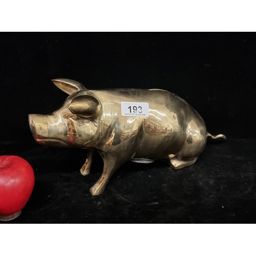 193 - A large very heavy brass piggy bank, with stopper to base, in a stylish polished finish.