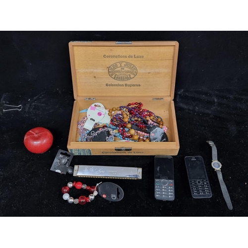 213 - A Cigar box filled with a mixed collection of items, including costume jewelry, a 