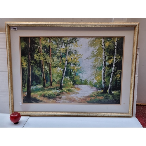 248 - A large high quality print showing a sun dappled pathway through the forest, housed in nicely gilded... 