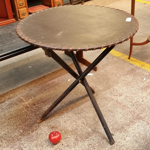 361 - An interesting folding table with leather clad table top, with stitched detail and wooden tripod bas... 