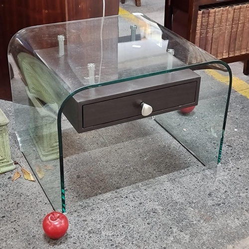 477 - A stylish designer coffee table featuring a rounded glass top and a floating wooden drawer with chro... 