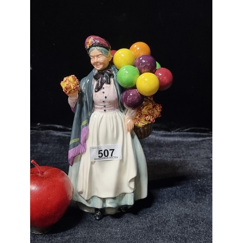 507 - A charming Royal Dalton porcelain figure depicting an older women carrying flowers and balloons, tit... 