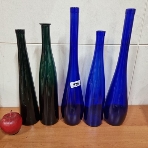 535 - Five tall glass coloured bottle vases in vibrant shades of blue and green. In various sizes. In very... 