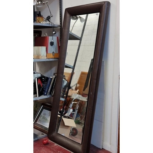 809 - A very large vertical wall mirror with padded frame upholstered in a brown leather. 
MM: 79 x 198 cm