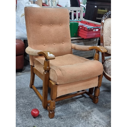 561 - A charming mid century Parker Knoll armchair featuring carved and button back detail. Upholstered in... 