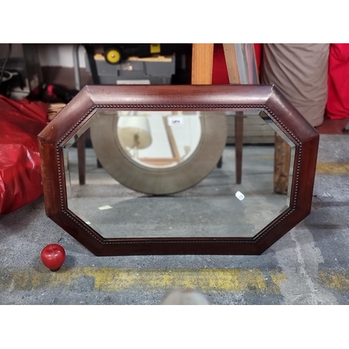 589 - A vintage octagonal wall mirror with bevelled glass pane and beaded wooden border. H54cm x L80cm