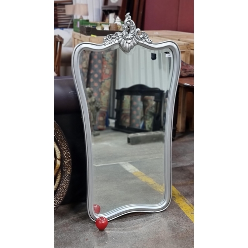 797 - An elegant Art Nouveau style wall mirror with bevelled glass and a silver toned frame with foliate f... 