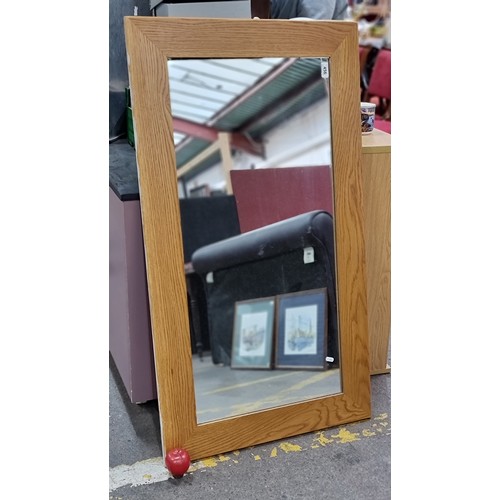 456 - A large wall mirror with wooden frame, can be displayed in either orientation. L122cm x W69cm.