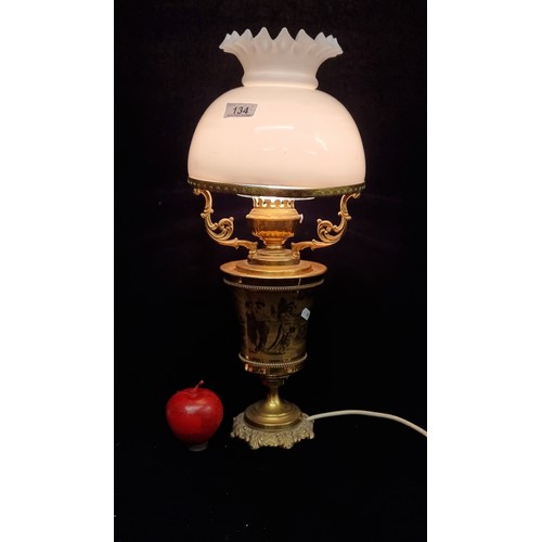 134 - An unusual vintage table lamp with an ornate brass base and romantic tableaux. Topped by a beautiful... 