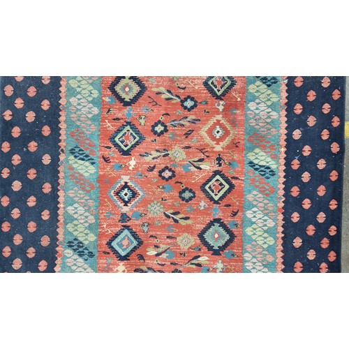 498 - Star Lot : A large Turkish wool blend rug from brand Lyric. In shades of red, turquoise and navy blu... 