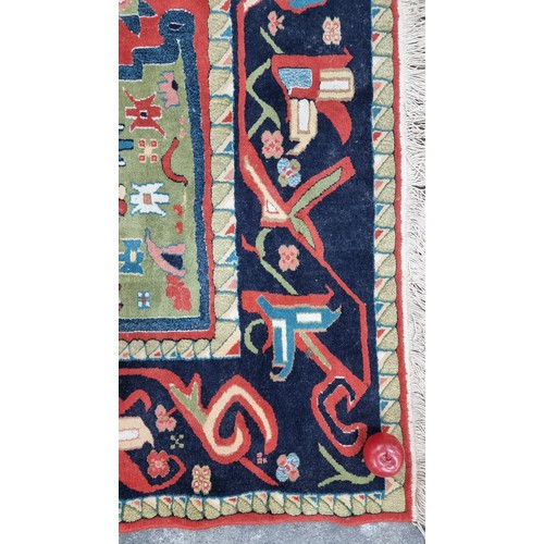 497 - Star Lot : A large Turkish wool blend rug from brand Lyric. In shades of red, navy blue, turquoise a... 