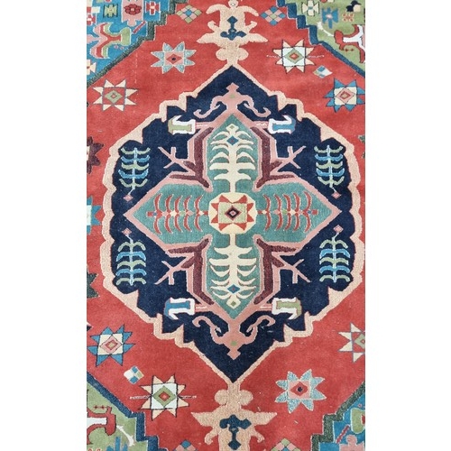 497 - Star Lot : A large Turkish wool blend rug from brand Lyric. In shades of red, navy blue, turquoise a... 