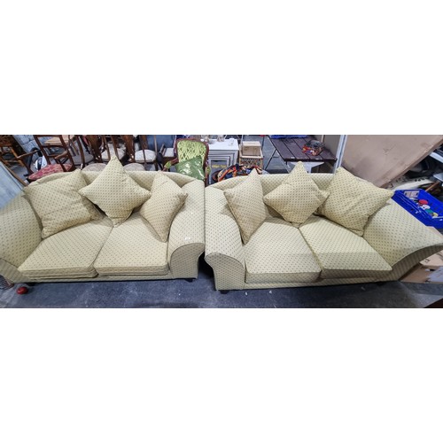 806 - A pair of stylish and comfortable two-seater sofas in a golden yellow shade with a subtle blue and g... 