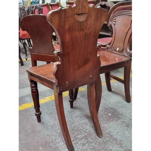 359 - A Victorian, mahogany shield back hall chair featuring acanthus leaf motifs and turned front legs. A... 