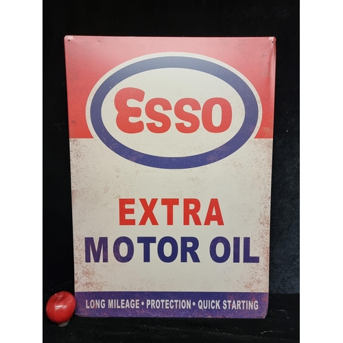 99 - A large metal sign advertising Esso Extra Motor Oil in the brands trademark shades of red, blue and ... 