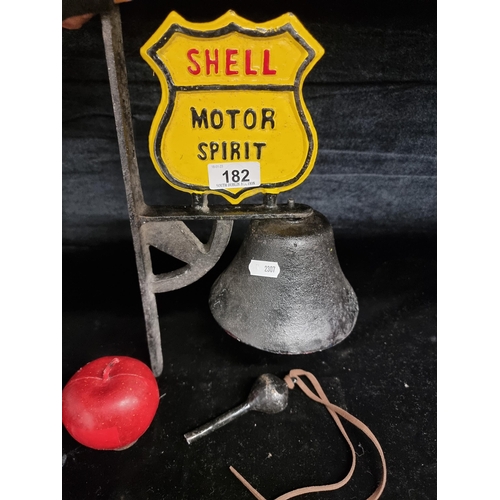 182 - A large cast metal Shell Motor Oil wall bell. With clanger. Some damage to clanger