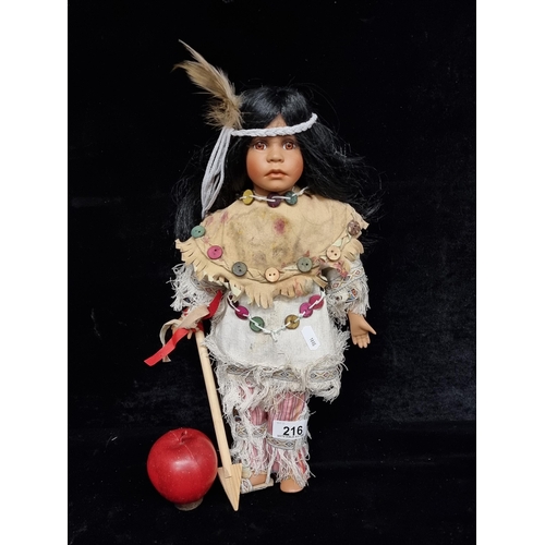 216 - A porcelain Native American girl doll dressed in a full traditional dress crafted from linen and col... 