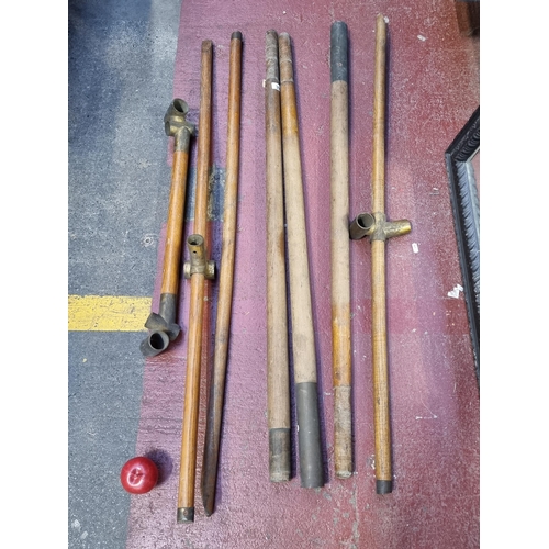 309 - A set of seven early 20th century vintage scaffold poles. These interlock by means of brass brackets... 