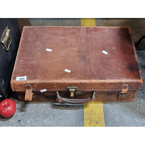 369 - A genuine leather suitcase with heavy brass hardware and pinstriped interior. Supplied with a heavy ... 