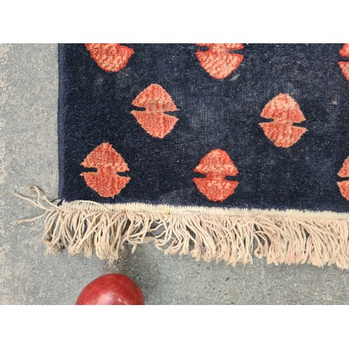 498 - A large Turkish rug in shades of red and blue and geometric design. With cream fringe L310cm x W200c... 