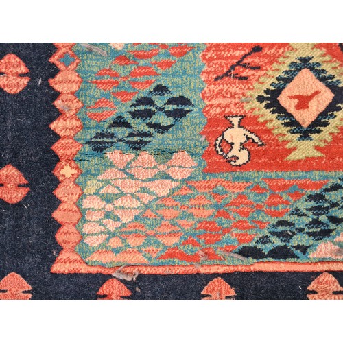 498 - A large Turkish rug in shades of red and blue and geometric design. With cream fringe L310cm x W200c... 