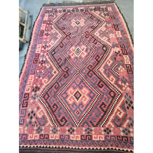 538 - Star lot : A very large handwoven wool floor rug with geometric pattern in bold shades of red, navy,... 