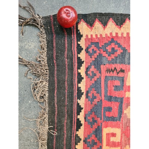 538 - Star lot : A very large handwoven wool floor rug with geometric pattern in bold shades of red, navy,... 