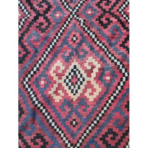 538 - Star lot : A very large handwoven wool floor rug with geometric pattern in bold shades of red, navy,... 