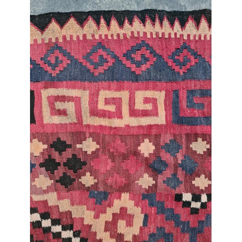 538 - Star lot : A very large handwoven wool floor rug with geometric pattern in bold shades of red, navy,... 