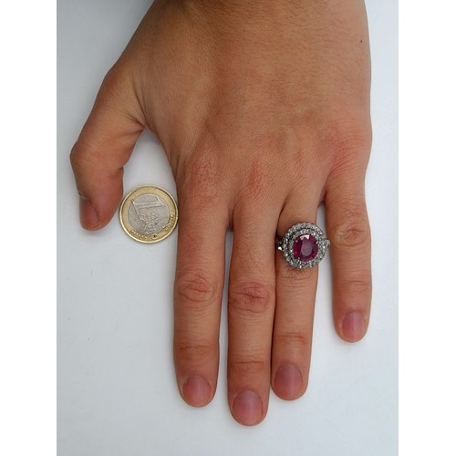 560 - Star Lot : A breath taking Ruby and Diamond ring, set with a graduated intricate double row halo of ... 