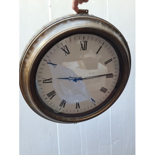 288 - A double sided wall clock in the form of a vintage railway station clock. Featuring brass toned beze... 