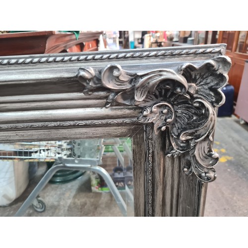 495 - A stylish large heavy wall overmantel  beveled mirror with ornate frame in a brushed silver finish. ... 