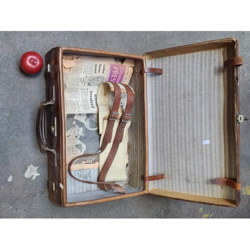 369 - A genuine leather suitcase with heavy brass hardware and pinstriped interior. Supplied with a heavy ... 