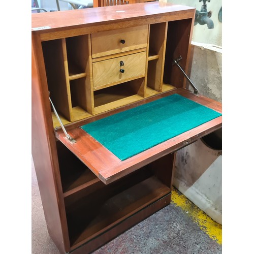 426 - A mid-century modern writing desk with dropped writing surface featuring green felt top. With six pi... 