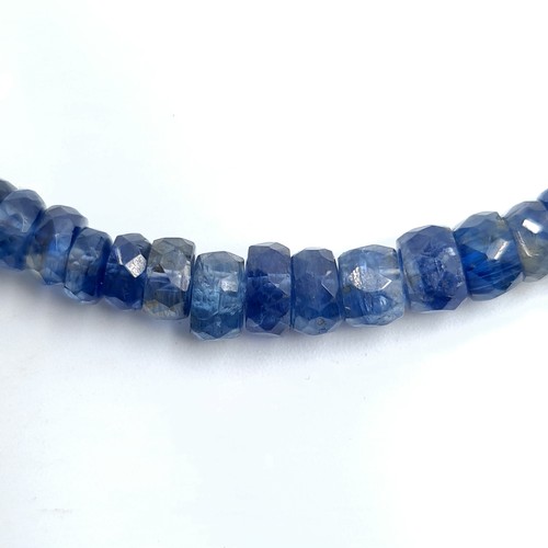 561 - A fine and heavy graduated midnight blue Kyanite single strand necklace, set with a Blue Topaz and S... 