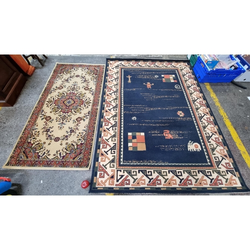 310 - Two good wool rugs including a larger example with navy, cream and orange design (L218cm x W160cm) a... 