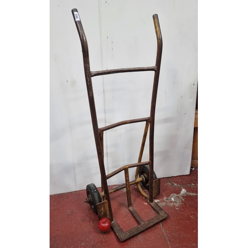 348 - A vintage steel two-wheeler hand truck. Furnished with solid rubber wheels. Very handy functional it... 