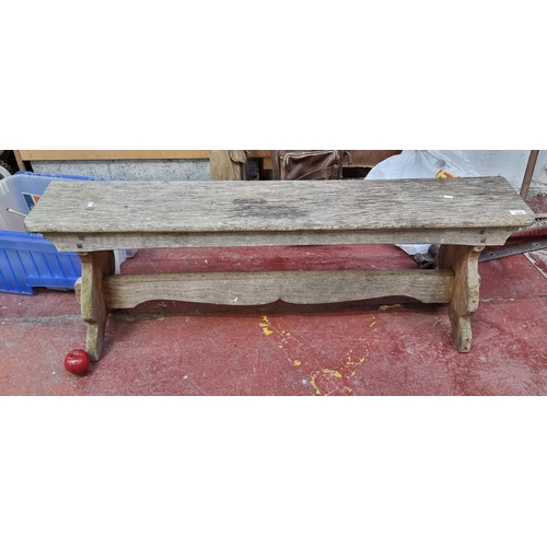 358 - A charming antique hand made Irish Elm bench. To seat two people. Featuring a carved stretcher and p... 