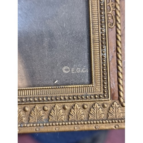 195 - A pair of antique  brass picture frames including a Roman Catholic example with an IHS crested detai... 