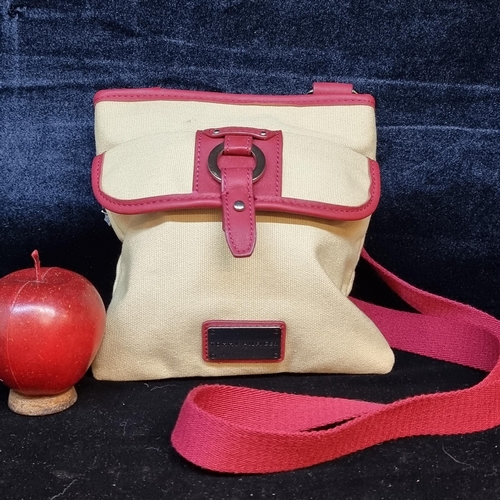 115 - A super Tommy Hilfiger cross body bag in a light tan canvas fabric with red leather detailing and si... 