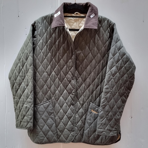 201 - A classic quilted women's jacket by Barbour. A striking example in a forest green quilted and insula... 