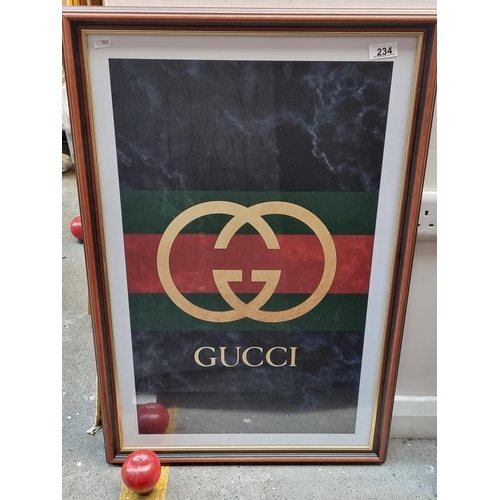 234 - A framed print of an an advertising poster for he designer brand Gucci. Featuring a marbled dark blu... 