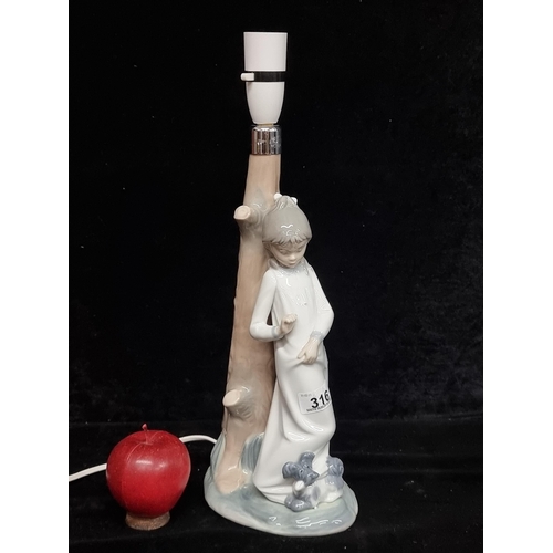 316 - A charming Nao porcelain lamp base. This hand made piece depicts a young girl with her dog companion... 