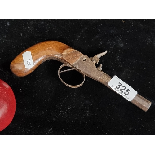 325 - An antique percussion pocket pistol with wooden grip and cast iron barrel.