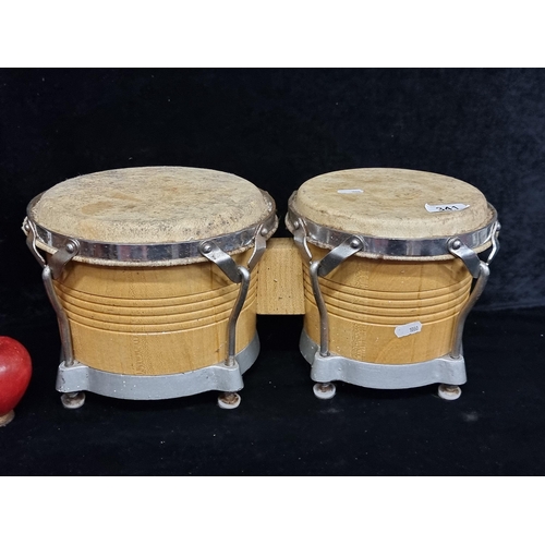 341 - A pair of good quality bongo drums in two different sizes with carved wooden bases and animal hide t... 