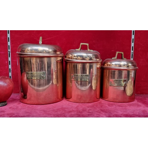 A trio of polished copper kitchen storage jars. With brass handle and plaque reading Tea, Coffee and Sugar.