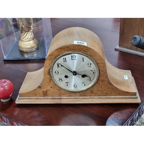 680 - A charming eight-day mantle clock. Housed in a 'Napoleon hat' oak case with handpainted dial.