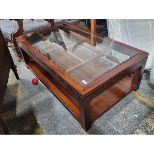 712 - A very striking large contemporary coffee table. Crafted from a stained wood with bevelled glass sur... 