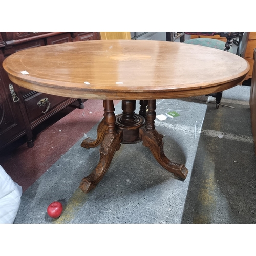 714 - An Edwardian satin wood dining table in an oval form. Featuring string inlay and central sunburst ca... 